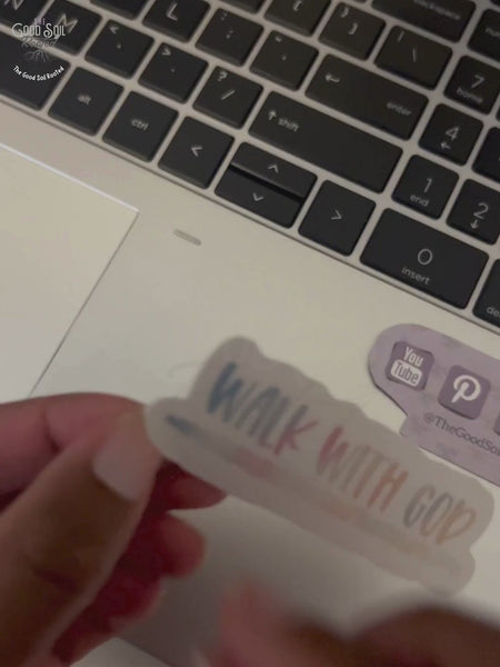 Video clip of hand placing a sticker that reads Walk With God onto a laptop.